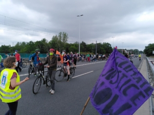 Raddemo, im Vordergrund eine Fahrradfahne mit dem Slogan "Climate Justice Now"