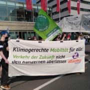 Bild vom Attacikka Banner auf der Demo mit dem Slogan "Klimagerechte Mobilität für alle: Verkehr der Zukunft nicht den Konzernen überlassen"