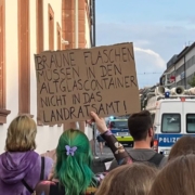 Einige Hinderköpfe und ein Papschild mit der Aufschrift: Braune Flaschen müssen in den Altglascontainer und nicht in das Landratsamt!