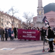 Menschenmenge mit Fahnen und Schildern, die vom Georg-Büchner-Platz kommt. Vorne ist ein Transpi mit der Aufschrift "Solidarität statt Rechtsruck" zu sehen.