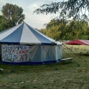 Bild vom Infozelt auf dem System Change Camp, am Zelt hängt ein Banner mit der Aufschrift "Willkommen beim schönen System Change Camp"