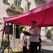 Ein Mann an einem Mikrophone unter einem Pavellion.